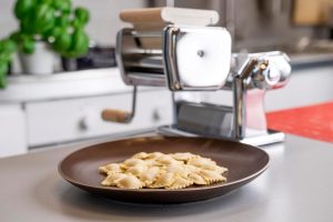 Home pasta-making with Imperia Classic Line ravioli accessory, authentic Italian steel design.