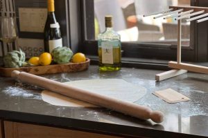 Italian craftsmanship pasta rolling pin with tapered ends in a kitchen.