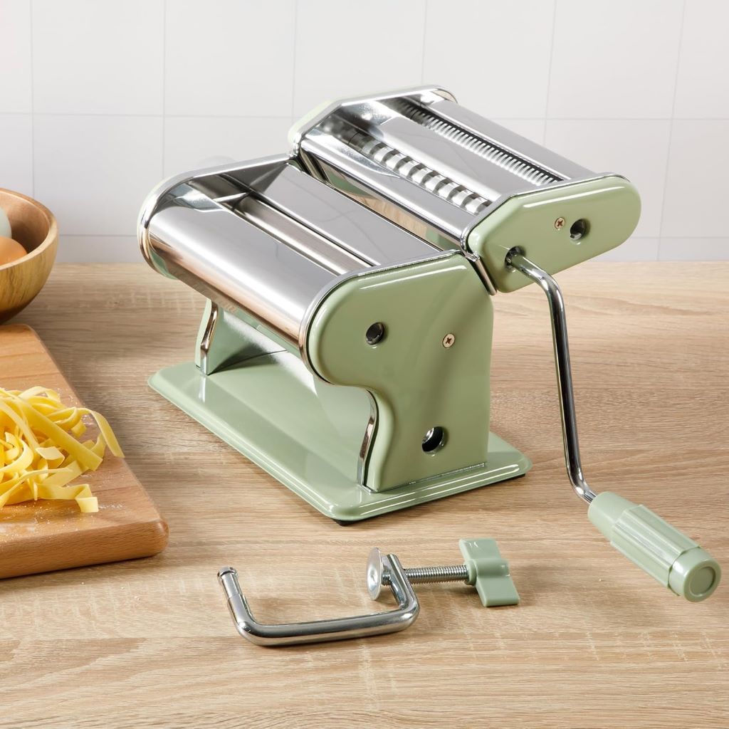 Stylish kitchen setup featuring the Sur La Table Va Bene Pasta Maker mid-use, with golden pasta strands and rustic countertop vibes.