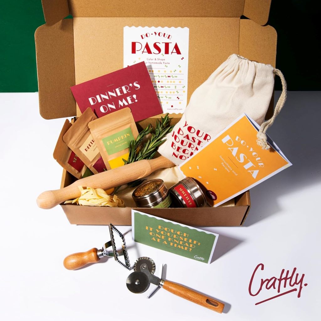 Home pasta making kit featuring rolling pin, pasta cutter, ravioli stamp, colorful pasta dyes, and spices.