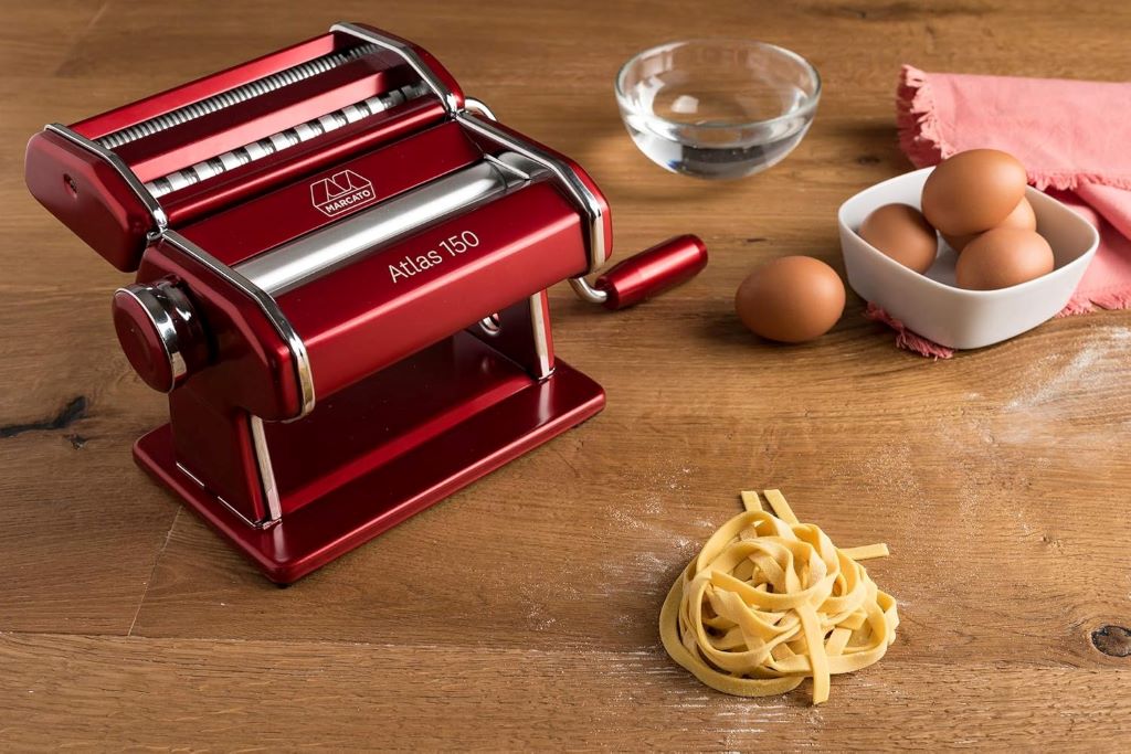 Marcato Atlas 150 Italian pasta maker in red, includes adjustable cutter and hand crank.