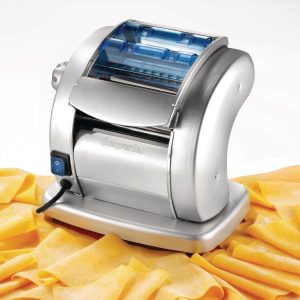 Electric pasta maker in use, producing fresh noodles in a home kitchen.
