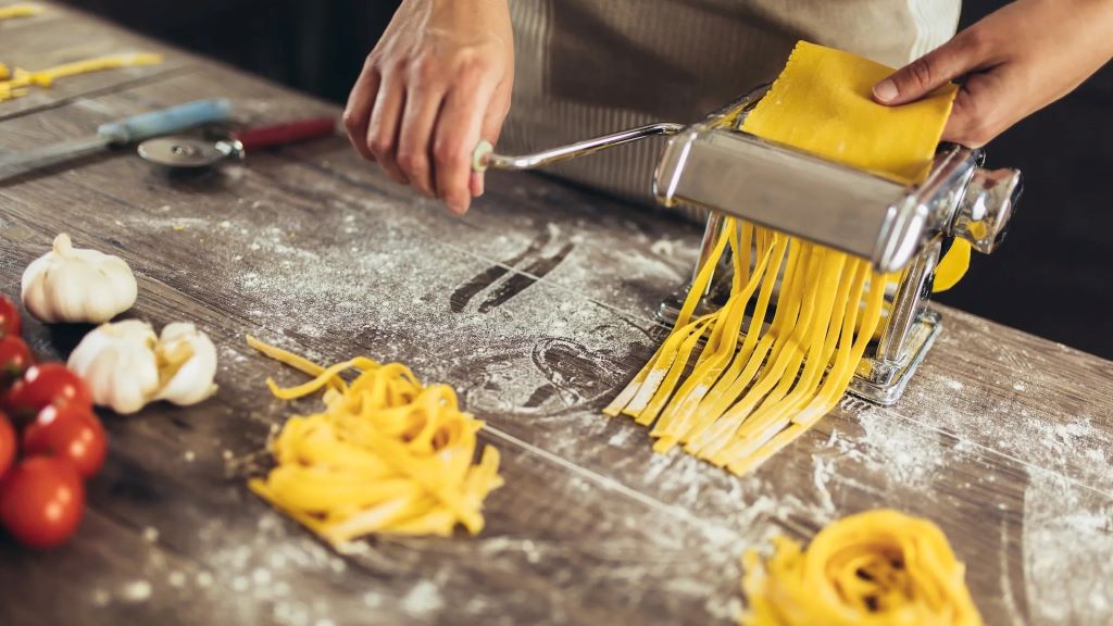 Close-up of a pasta maker being cleaned properly with tips to prevent damage.