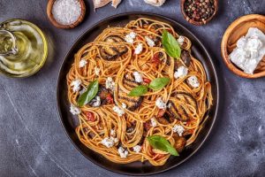 Close-up of creamy carbonara and spicy curry pasta served side by side.