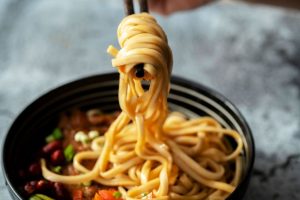 World map background with famous pasta and noodle dishes from different countries.
