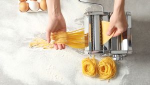Home cook examining a pasta maker that stopped working to find the problem.