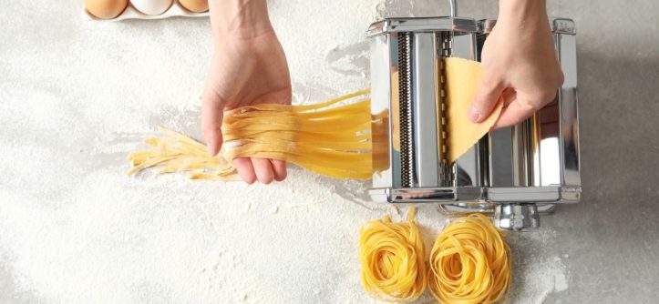 Home cook examining a pasta maker that stopped working to find the problem.