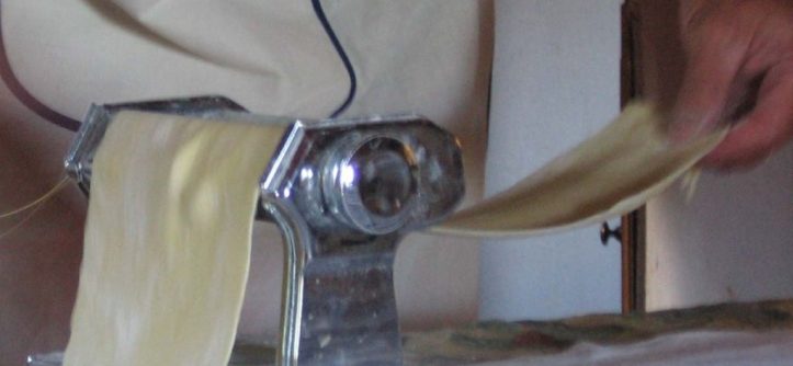 Person troubleshooting a pasta maker that stopped working in the kitchen.