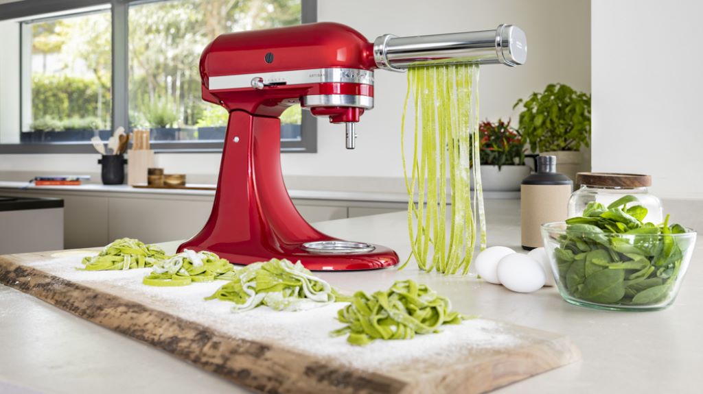 Fresh pasta sheets being rolled and cut using KitchenAid pasta maker attachments