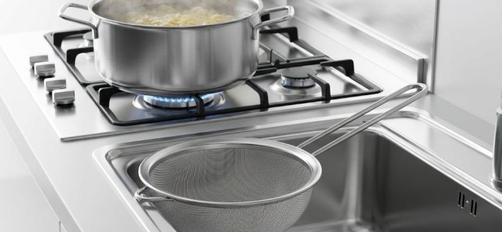 Safely draining boiling water using a mesh pasta strainer in a home kitchen