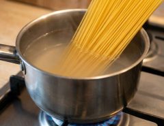 Stainless steel pot boiling pasta on a stove