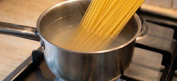 Stainless steel pot boiling pasta on a stove