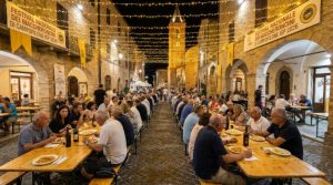 Golden threads of freshly prepared Maccheroncini di Campofilone IGP egg pasta being tossed with meat ragù on a wooden board at the Campofilone festival in Italy